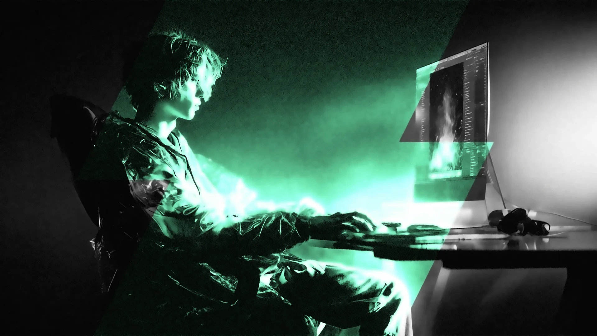 An editor in a reflective jacket works at a monitor in a dark studio, lit by emerald-green light.